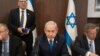 FILE - Israeli Prime Minister Benjamin Netanyahu eats an apple slice to mark the upcoming Jewish New Year holiday during the weekly Cabinet meeting in Jerusalem on Sept 10, 2023.