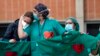 Health workers comfort each other during a memorial for a co-worker who died of COVID-19, at the Severo Ochoa Hospital, in Leganes, Spain, April 10, 2020. 