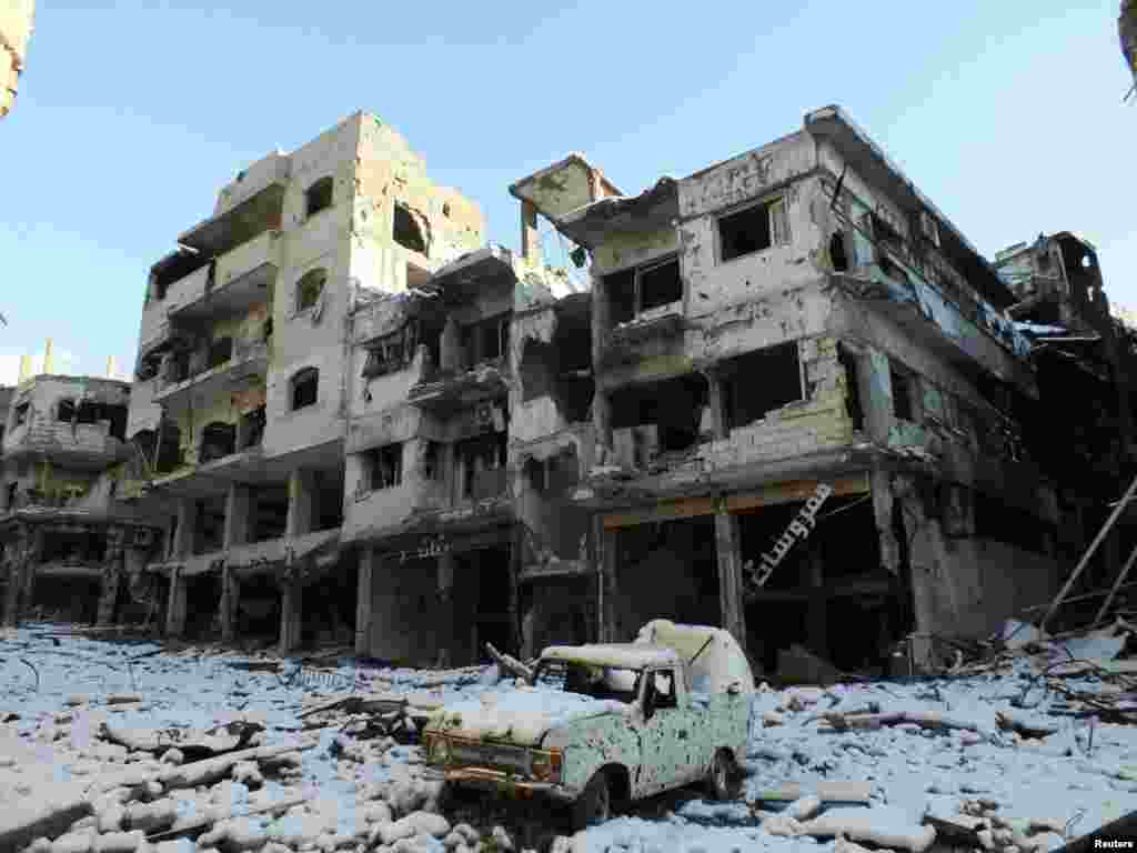 A damaged car and buildings covered with snow are seen in the Jouret al Shayah area of Homs, Syria, January 10, 2013.