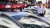 FILE - A police officer stands in a row of police cars parked in Times Square in New York.