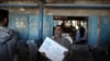 FILE - Palestinians receive food aid at a U.N. Relief and Works Agency warehouse in the Shati refugee camp, Gaza City, Jan. 14, 2018.