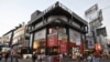 People walk past an American apparel brand store in Bangalore, India, January 11, 2012. 
