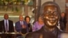 South African President Jacob Zuma, second left, in background with a bust of former South African President Nelson Mandela, center, outside Parliament before giving the State of the Nation address in the city of Cape Town, South Africa, June 17, 2014.