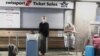 Passengers wait for confirmation of flights outside the Swissport Ticket Sales counter as several airlines stopped flying out of South Africa, amidst the spread of the new Omicron variant at O.R. Tambo International Airport in Johannesburg, South Africa, 