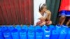 FILE - A resident queues with plastic containers to collect drinking water in Rosario.