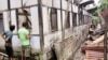 Indian people inspect a house damaged by vandals in Kokrajhar, India, July 23, 2012.