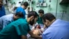 Shahed Qishtah, a nine-year-old Palestinian girl, receives medical care at an emergency room of the Kamal Adwan hospital in Beit Lahia after she was injured in an Israeli strike while playing on July 22, 2014 in the northern Gaza Strip. 