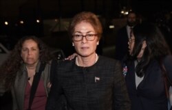 FILE - Former U.S. Ambassador to Ukraine Marie Yovanovitch, center, flanked by lawyers, aides and Capitol police, leaves the Capitol, Oct. 11, 2019.