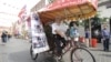 Chen Guanming, who cycled from China to London, poses for a photograph in his rickshaw in Chinatown, central London, July 28, 2012. 
