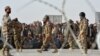 FILE - People wait to cross into Afghanistan at Pakistan's Chaman border post, Sept. 1, 2016. Afghanistan opposes a new Pakistani flag ceremony at the key border crossing between the countries.