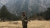 FILE - An Afghan security force personnel keeps watch near his check post in Parun, capital of Nuristan province, Afghanistan.