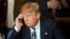 FILE - Republican presidential candidate Donald Trump listens to his mobile phone during a lunch stop in North Charleston, South Carolina, Feb. 18, 2016.