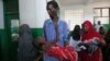 Internally displaced man carries cholera-stricken son through paediatric ward, Banadir hospital, Mogadishu, Aug. 25, 2011.