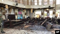 Un soldado observa el interior de la catedral católica en Jolo, capital de la provincia de Sulu en el sur de las Filipinas, después de dos explosiones de bomba que dejaron 20 muertos, el 27 de enero de 2019. Foto provista por WESMINCOM Fuerzas Armadas de las Filipinas.