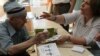 A polling station official checks the documents of an elderly voter as he waits to cast his vote for the Turkey's presidential election in Ankara, Aug. 10, 2014.