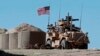 FILE - In this April 4, 2018 file photo, a U.S. soldier sits on an armored vehicle at a newly installed position, near the tense front line between the U.S-backed Syrian Manbij Military Council and the Turkish-backed fighters, in Manbij, north Syria. 