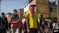FILE - People walk in the streets of the Isotry district of Madagascar capital Antananarivo on May 16, 2020. 