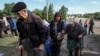 Residents from Vovchansk and nearby villages wait for buses amid an evacuation due to Russian shelling, amid Russia's attack on Ukraine, at an undisclosed location near the town of Vovchansk in the Kharkiv region, Ukraine, May 10, 2024.