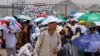 Para jemaah haji berjalan dengan payung di tengah cuaca yang sangat panas, di Mina, Arab Saudi, 18 Juni 2024. (Foto: REUTERS/Saleh Salem)