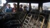 FILE - People look at the burned remains of a passenger vehicle on the outskirts of Srinagar in Indian-controlled Kashmir, Oct. 17, 2016. Kashmir is witnessing the largest protests against Indian rule in recent years, sparked by the July 8 killing of a popular rebel commander by Indian soldiers.