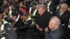 Cardinal George Pell, center right, is surrounded by police as he arrives at the Melbourne Magistrates Court in Melbourne, Australia, July 26, 2017. 