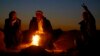 Turkish Kurds warm themselves around an open fire as they watch the Syrian town of Kobani, near the Mursitpinar border crossing, on the Turkish-Syrian border in the southeastern town of Suruc, Turkey, Oct. 21, 2014.