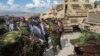 Le président kényan William Ruto (veste grise) rendant visite aux policiers de son pays déployés en Haïti dans le cadre d'une force multinationale gérée par l'ONU.