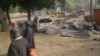 Children stand near the scene of an explosion in a mobile phone market in Potiskum, Nigeria, Jan. 12, 2015.