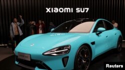 资料照片：参观者在位于北京的小米公司展出的首款电动汽车 SU7 周围拍摄。(2023 年12月28日)