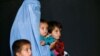 FILE - An Afghan family, returning from Pakistan, watch a short video clip about mines during a mines and explosives awareness program at a United Nations High Commissioner for Refugees (UNHCR) registration centre in Kabul, Sept. 27, 2016. 