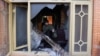 An Afghan man removes burning items from the house of an Afghan member of parliament that was attacked by Taliban, Dec. 21, 2016, in Kabul, Afghanistan.