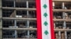 FILE - A banner with representations of the Lebanese flag hangs on a damaged building in a neighborhood near the site of last week's explosion that hit the seaport of Beirut, Lebanon, Aug. 12, 2020. 