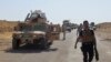 FILE - Military vehicles of Iraqi security forces on a road during clashes with Islamic State (IS) militants in the Hamrin mountains in Diyala province.