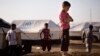 A boy, who fled from the violence in Mosul, stands near tents in a camp for internally displaced people on the outskirts of Erbil in Iraq's Kurdistan region, June 14, 2014. 