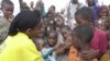 FILE - A World Health Organization official dispenses polio vaccine in Tosweyn village, Somalia. Investing in children's health and education spurs countries' economic development, a new U.N. report says. 