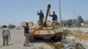 FILE - Members of Libyan pro-government forces on a tank in Benghazi, May 21, 2015