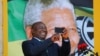Cyril Ramaphosa utilise son téléphone lors d'un rassemblement pour commémorer l'année du centenaire de Nelson Mandela au Cap, en Afrique du Sud, le 11 février 2018.