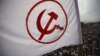 A party flag of the Unified Communist Party of Nepal (Maoist) flutters above the crowd during a mass gathering in Kathmandu, June 15, 2012. 