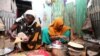 An internally displaced Somali woman and her daughter prepare their Iftar meal during the month of Ramadan at the Shabelle makeshift camp in the Hodan district of Mogadishu, Somalia, May 8, 2020.