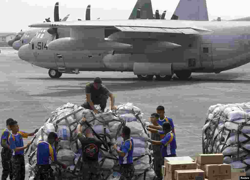Philippine and U.S. military personnel prepare to load relief goods on a U.S. C-130 plane for victims of Typhoon Haiyan, Villamor Air Base, Nov. 11, 2013.