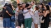 A group of people react after placing flowers as a tribute near a crime scene at Bondi Junction in Sydney, April 15, 2024, after several people were stabbed to death at a shopping on April 13. 