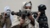 FILE - Former Afghan Taliban fighters carry their weapons before handing them over as part of a government peace and reconciliation process at a ceremony in Jalalabad, Jan. 12, 2016. 