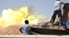 A tank belonging to the Western Shield, a branch of the Libya Shield forces, fires during a clash with rival militias around the former Libyan army camp, Camp 27, in the 27 district, west of Tripoli, Aug. 22, 2014. 