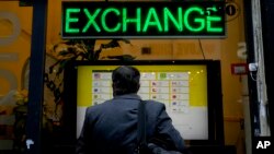 FILE - A man checks rates at a money exchange house in Buenos Aires, Argentina, July 14, 2022.