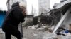 A woman reacts as she stands at a market that, according to locals, was recently damaged by shelling, in Donetsk, eastern Ukraine, Jan. 19, 2015. 