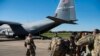 This Oct. 29, 2018 photo provided by the U.S. Air Force shows deployers from Headquarters Company, 89th Military Police Brigade, Task Force Griffin getting ready to board a C-130J Super Hercules from Little Rock, Arkansas, at Fort Knox, Kentucky.