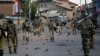 FILE - Indian government forces patrol a street dotted with rocks and bricks used during a protest in Srinagar, Indian-controlled Kashmir, Sept. 7, 2016.