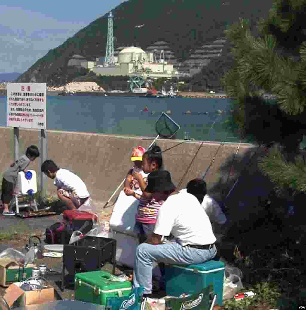 A family fishes and picnics across the bay from the Monju nuclear reactor facility. (Steve Herman/VOA)