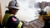 Fire fighters put out a fire on the roof of a building near the Russian market in Phnom Penh March 18, 2009. Twelve houses were destroyed in the blaze but no one was injured, police said. It is not known how the fire was started. REUTERS/Chor Sokunthea 