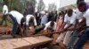 Des volontaires déposent dans caveau les restes des victimes du génocide de 1994, à Murambi, est du Rwanda, 07 avril 2005. epa / RICKY GARE